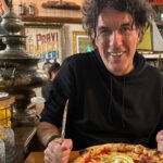 Bojan Mušćet za stolom u Pivnici Cont u Rijeci, ispred pizze Storia all'Arrabiata s burratom