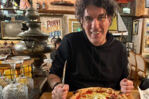 Bojan Mušćet za stolom u Pivnici Cont u Rijeci, ispred pizze Storia all'Arrabiata s burratom